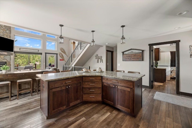 kitchen featuring pendant lighting, dark hardwood / wood-style floors, and a kitchen island with sink