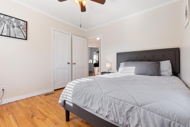 bedroom featuring light wood-type flooring, a closet, ceiling fan, and ornamental molding