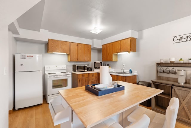 2334 S Davenport St, Sturgis, SD 57785 - kitchen featuring white appliances, brown cabinetry, light wood-style floors, and light countertops