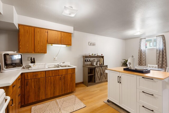 2334 S Davenport St, Sturgis, SD 57785 - kitchen featuring light countertops, range, a sink, light wood finished floors, and brown cabinets