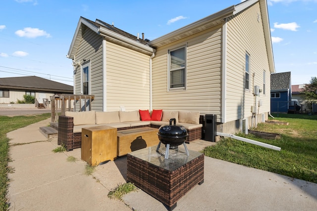 back of house featuring an outdoor living space with a fire pit and a patio