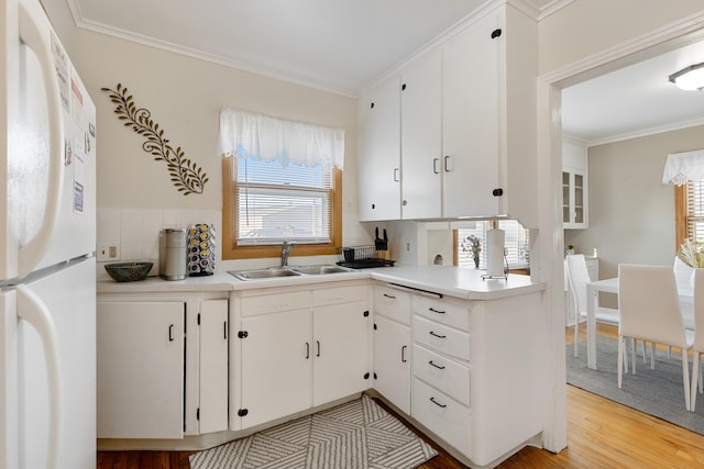 2334 S Davenport St, Sturgis, SD 57785 - kitchen featuring freestanding refrigerator, a sink, white cabinetry, and crown molding