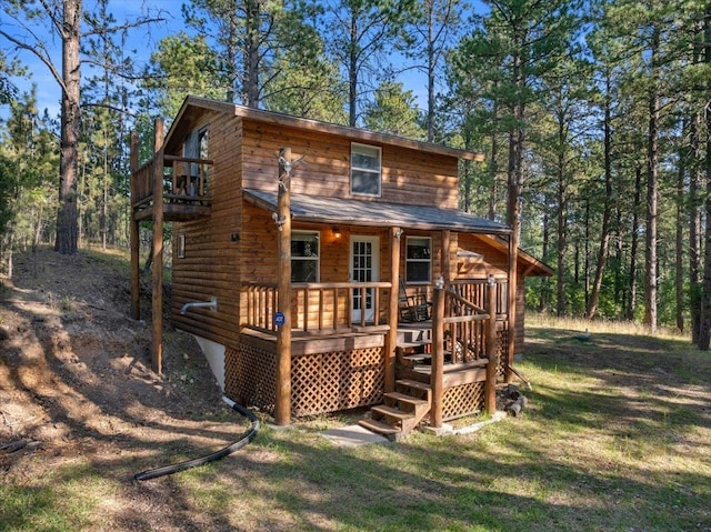 back of house with a deck and a lawn