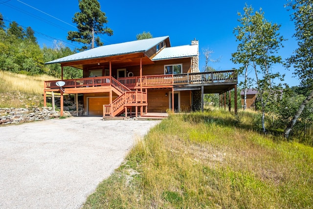 log cabin featuring a wooden deck and a garage