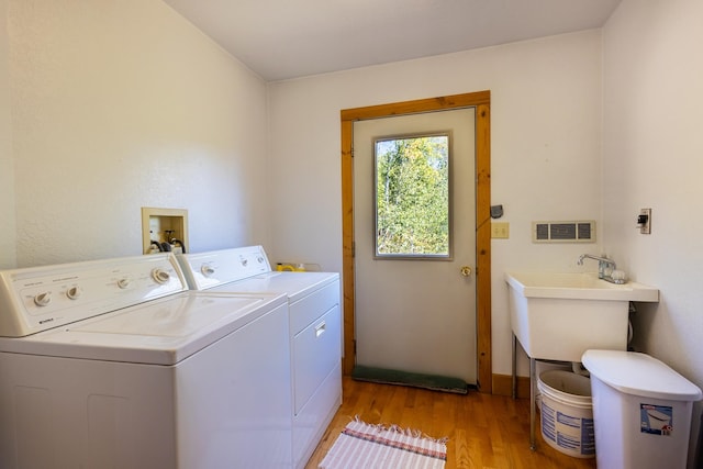 washroom with washer and dryer and light hardwood / wood-style flooring