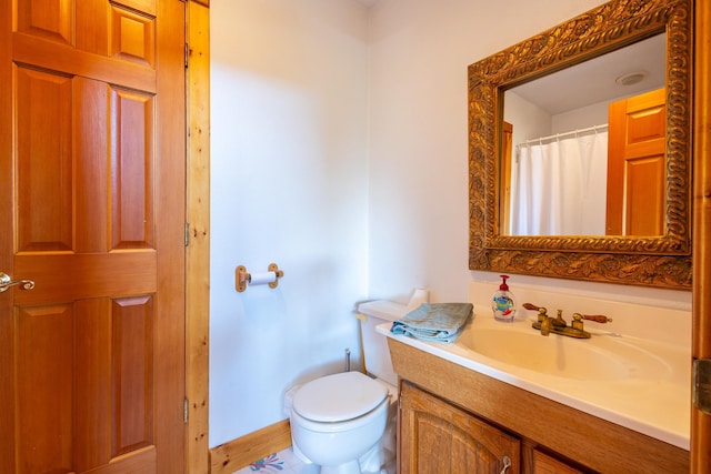 full bath featuring vanity, baseboards, and toilet