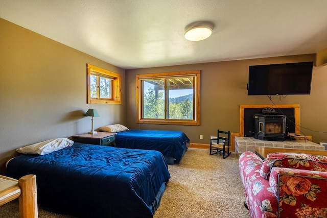 carpeted bedroom with a wood stove and baseboards