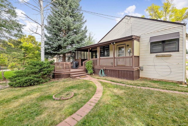 view of front of house with a deck and a front yard