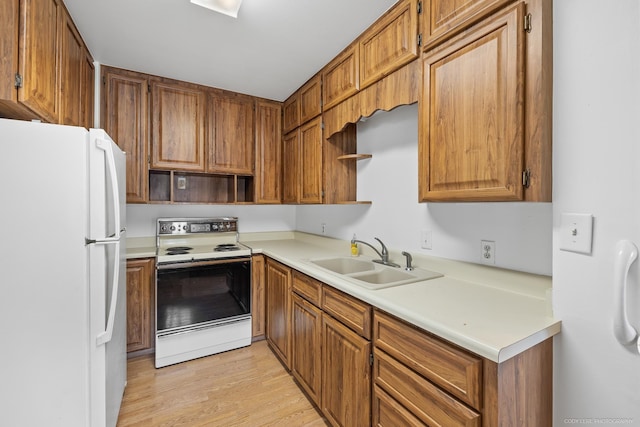 kitchen featuring light wood-type flooring, white appliances, and sink