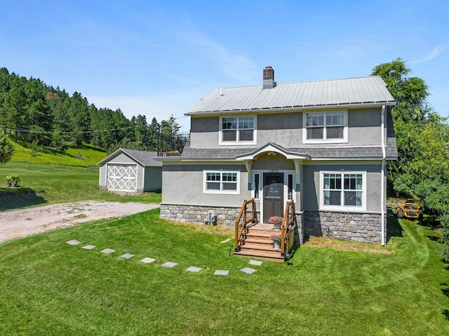 view of front of house with a storage shed and a front yard