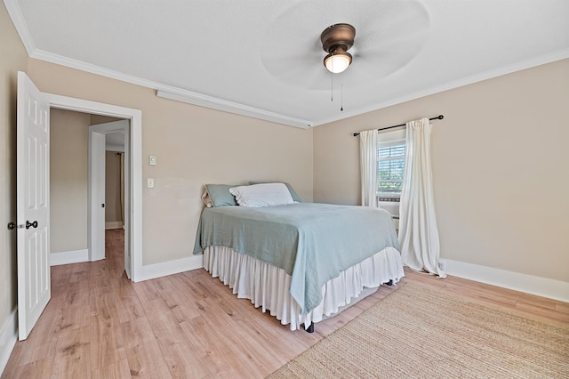 bedroom with ornamental molding, ceiling fan, and light hardwood / wood-style floors