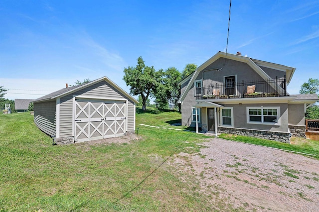 rear view of house featuring a balcony, a storage shed, and a lawn