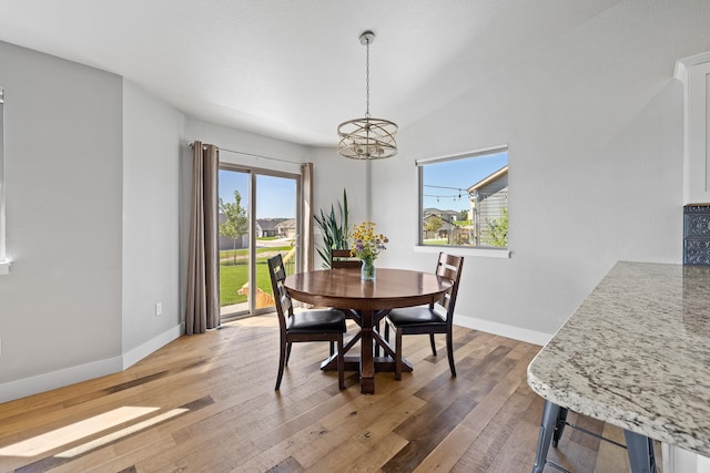 dining space featuring a notable chandelier and wood-type flooring