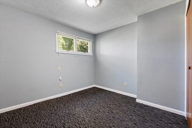 carpeted empty room featuring a textured ceiling