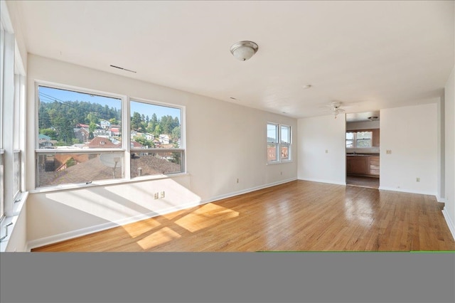 unfurnished living room with light wood-type flooring and ceiling fan