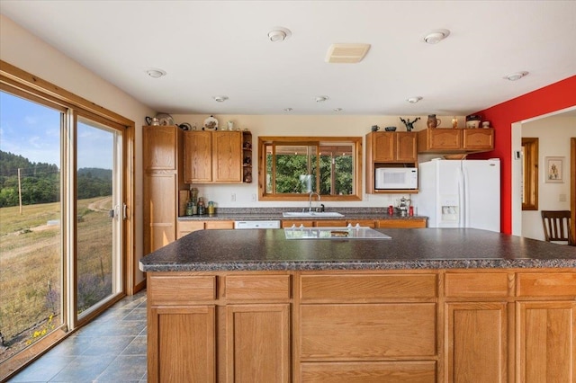 kitchen with a center island with sink, sink, and white appliances