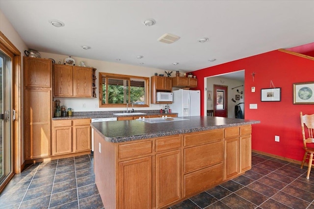 kitchen featuring white appliances, a kitchen island, and sink