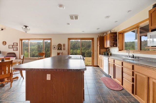 kitchen with a center island, plenty of natural light, white appliances, and sink