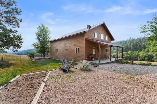 view of side of property featuring a yard and a patio