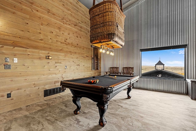 rec room with billiards, wooden walls, a chandelier, and a towering ceiling