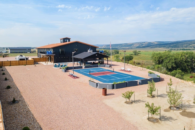 view of pool with tennis court and a rural view