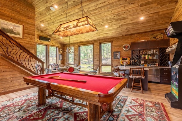 playroom with wood walls, high vaulted ceiling, bar area, billiards, and light hardwood / wood-style floors