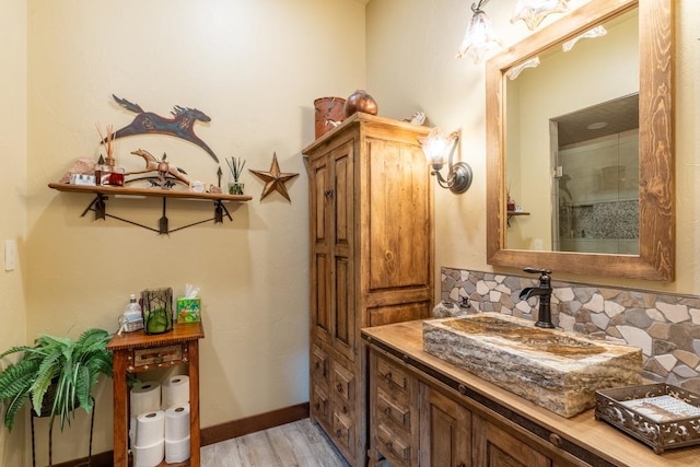 bathroom with vanity, hardwood / wood-style floors, and decorative backsplash