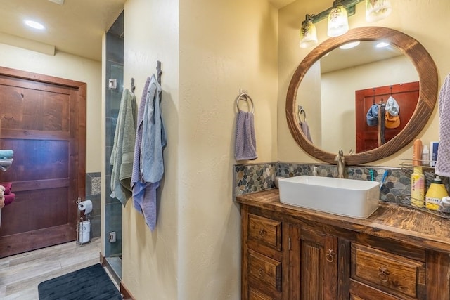 bathroom featuring hardwood / wood-style flooring, vanity, and tasteful backsplash