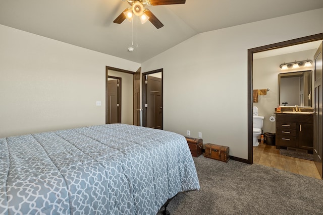 carpeted bedroom featuring ceiling fan, sink, ensuite bath, and vaulted ceiling