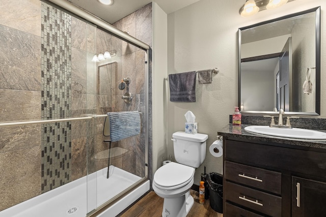 bathroom with hardwood / wood-style floors, vanity, toilet, and an enclosed shower