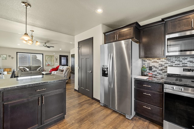 kitchen featuring ceiling fan, dark brown cabinets, a textured ceiling, appliances with stainless steel finishes, and dark hardwood / wood-style flooring