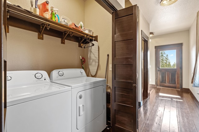 laundry area featuring baseboards, laundry area, wood-type flooring, a textured ceiling, and washing machine and dryer