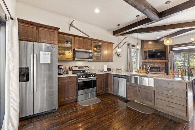 kitchen featuring glass insert cabinets, dark wood finished floors, beamed ceiling, appliances with stainless steel finishes, and a peninsula