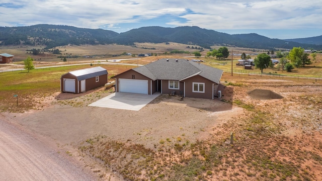 ranch-style home with a mountain view, a rural view, and a garage