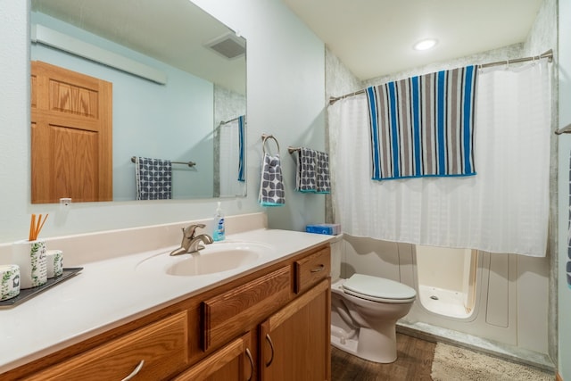 bathroom featuring walk in shower, hardwood / wood-style floors, vanity, and toilet