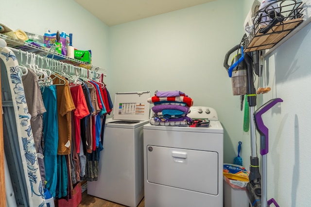 clothes washing area featuring washer and dryer and hardwood / wood-style flooring