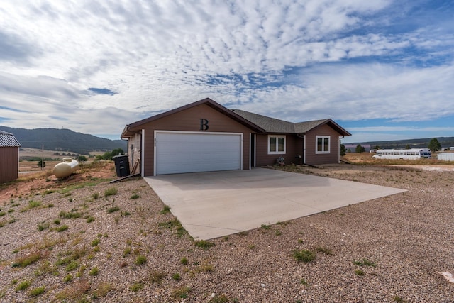 view of front of property featuring a mountain view, a rural view, and a garage