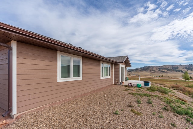 view of property exterior featuring a rural view and a mountain view