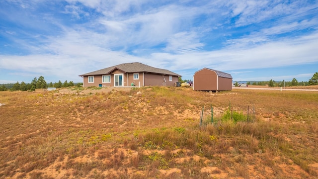 view of yard featuring a rural view and a storage unit