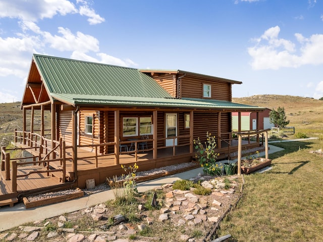 rear view of property featuring a deck and a yard