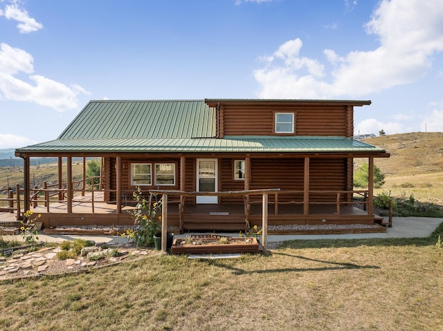 log-style house with a front lawn and a wooden deck