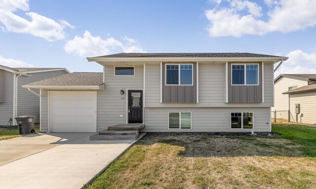 split foyer home with a garage and a front yard