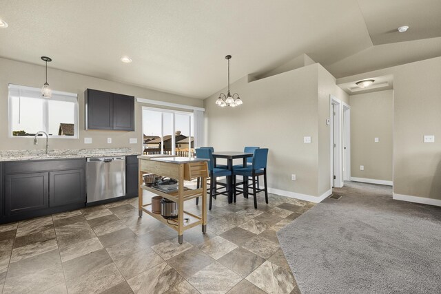 kitchen with pendant lighting, lofted ceiling, carpet flooring, stainless steel dishwasher, and light stone countertops