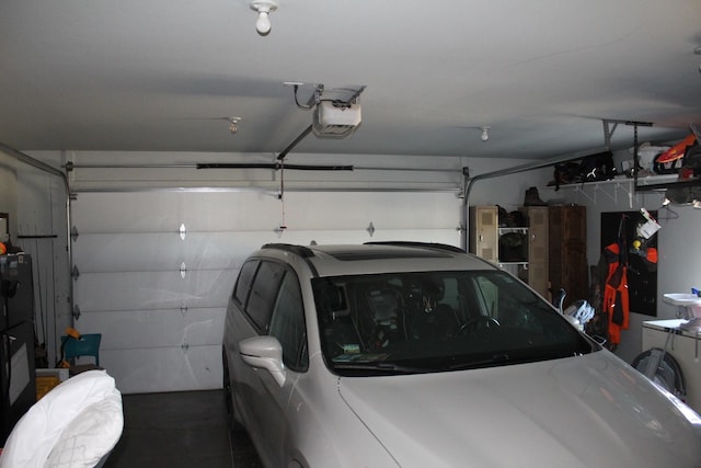 garage featuring a garage door opener and black fridge