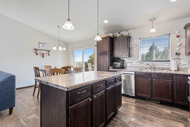 kitchen featuring hanging light fixtures, tasteful backsplash, a kitchen island, dishwasher, and dark hardwood / wood-style flooring