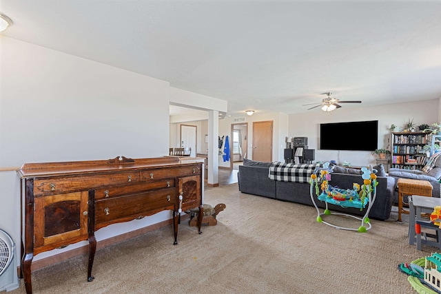 carpeted living room with ceiling fan