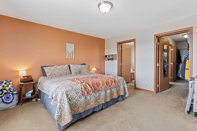 carpeted bedroom with a spacious closet, a closet, and ensuite bathroom