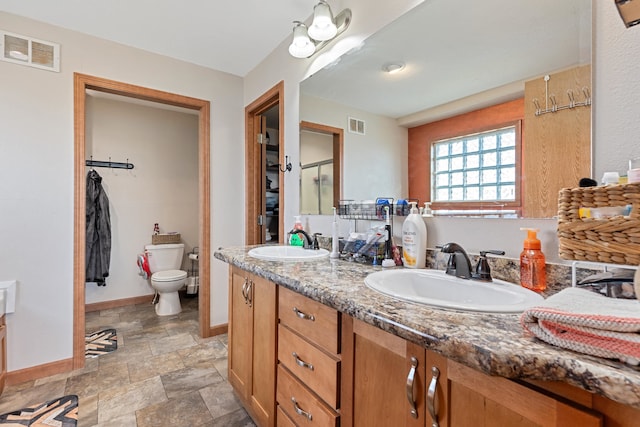 bathroom with vanity, toilet, and a shower with shower door