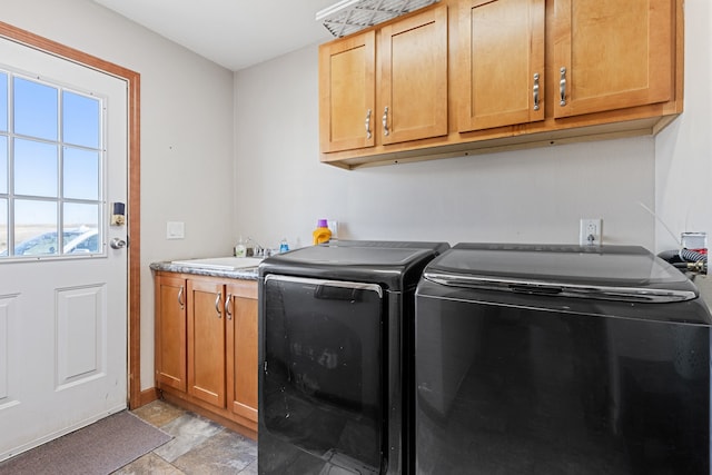 clothes washing area featuring cabinets, washer and clothes dryer, and sink