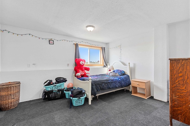 bedroom with a textured ceiling and dark carpet